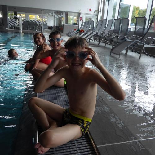 Kinder beim Schwimmkurs am Beckenrand sitzend