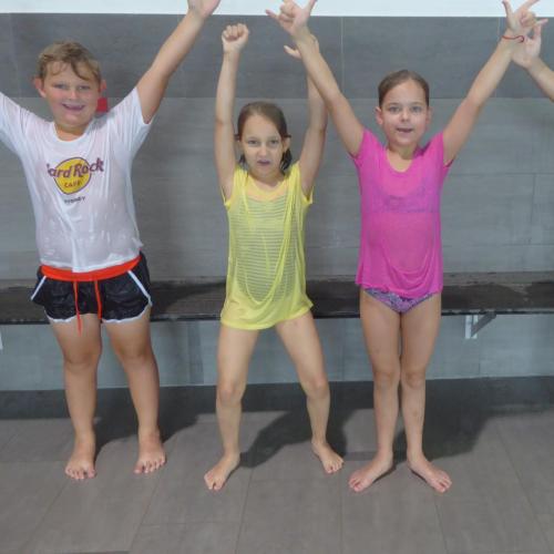 Kinder mit nassen T-Shirts beim Schwimmkurs